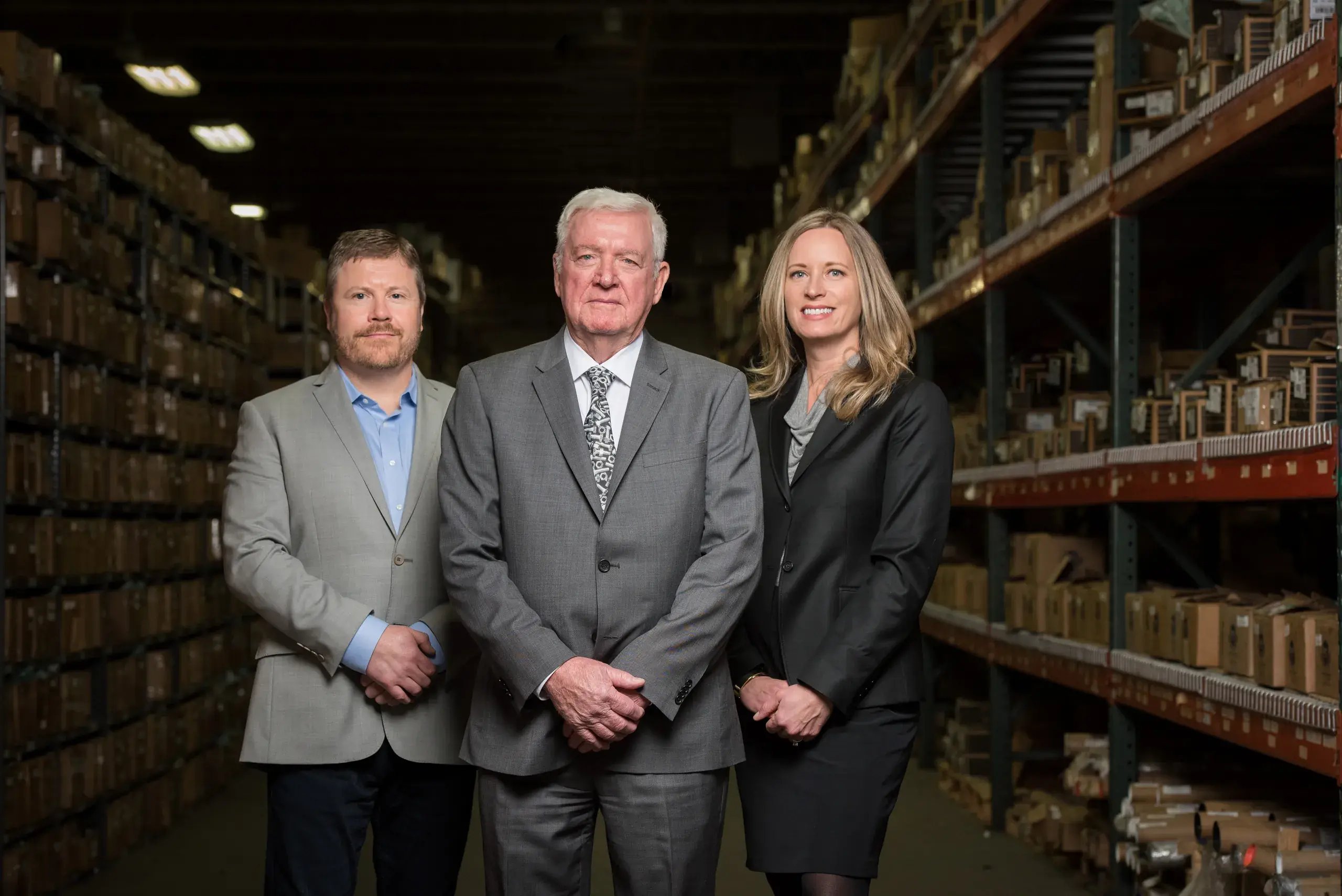 Three members of the Suburban Bolt leadership team standing in a warehouse aisle