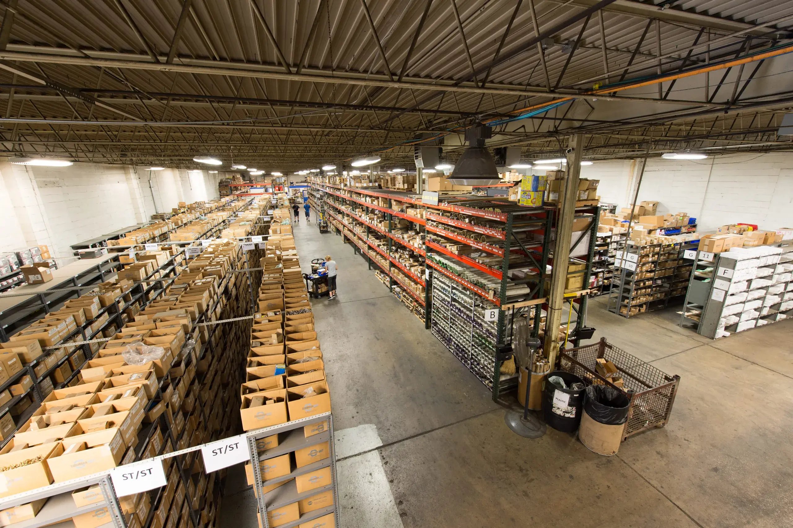 Wide view of long warehouse aisles stocked with boxed fasteners and pallet racking