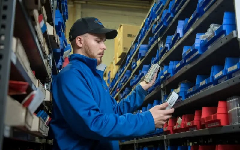 Suburban Bolt employee scanning bin inventory with a handheld scanner
