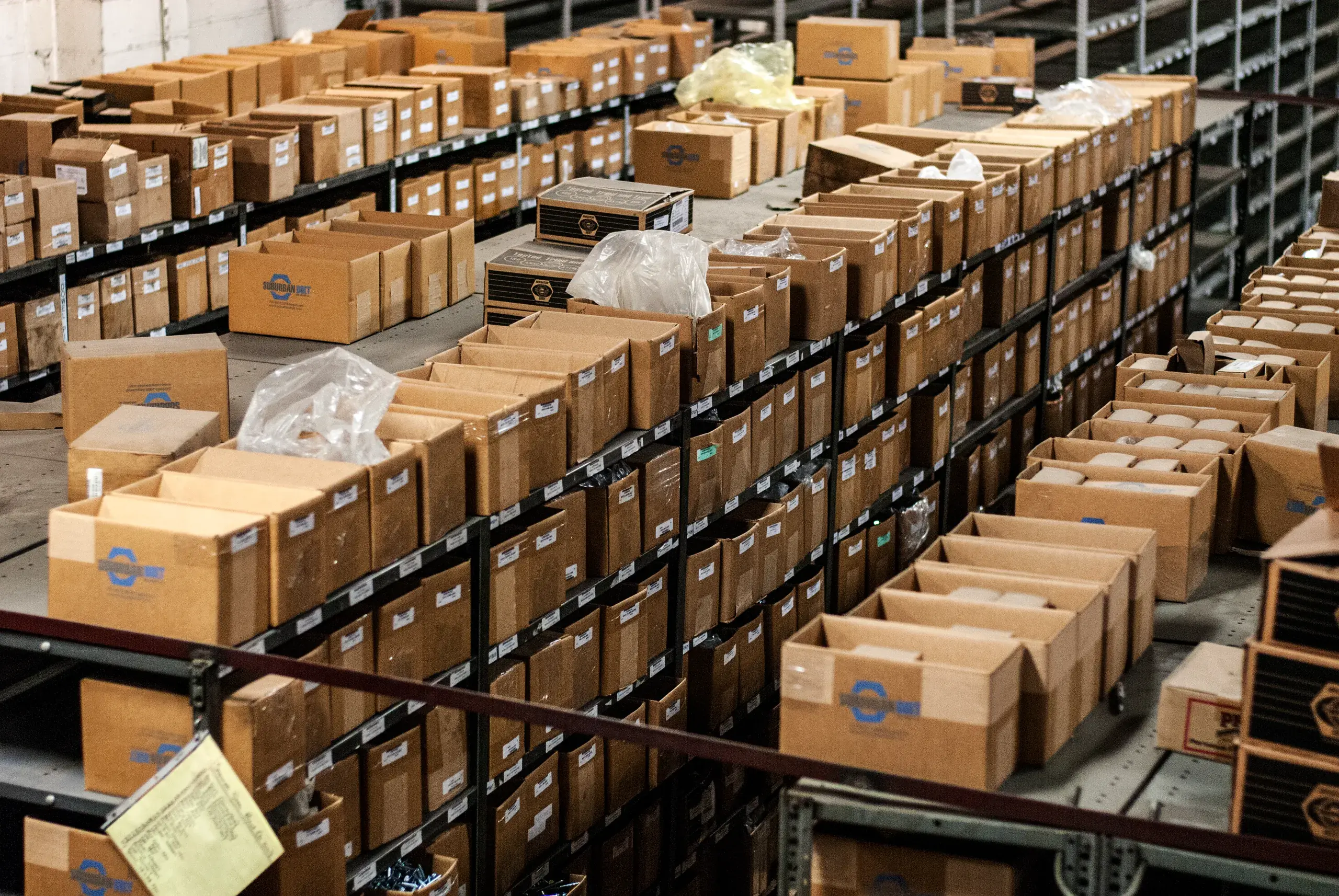 Rows of open Suburban Bolt boxes on warehouse bin shelving